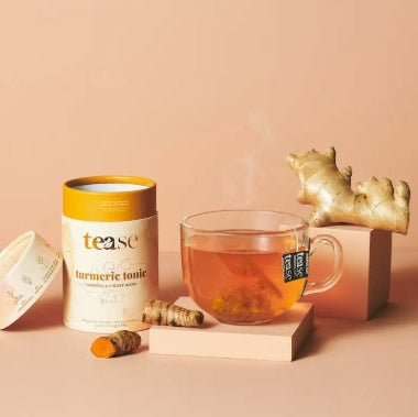Tea with 'ease' turmeric tonic packaging on a peach background
