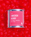 Candle container labeled 'Swedish Berry' on a red background with berry graphics