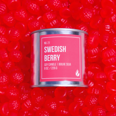 Candle container labeled 'Swedish Berry' on a red background with berry graphics