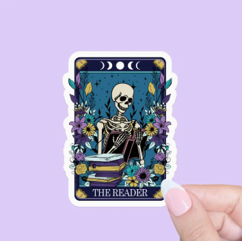 Sticker of 'The Reader' tarot card held by a hand against a purple background