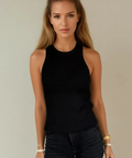 Woman wearing a black sleeveless top and black pants against a plain background