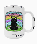 White mug with a black cat illustration and motivational quote on a white background
