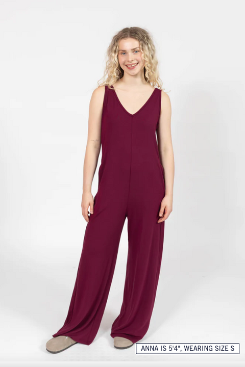 Woman wearing a burgundy jumpsuit on a white background