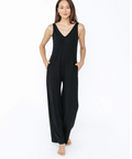 Woman wearing a black sleeveless jumpsuit on a white background