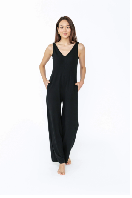 Woman wearing a black sleeveless jumpsuit on a white background