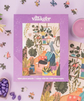 Villager puzzle box with a colorful illustration of a woman in a chair surrounded by plants on a patterned background.
