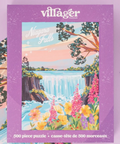 A Villager Puzzles 'Niagara Falls' 500-piece jigsaw puzzle box, featuring a colorful illustration of the waterfall surrounded by flowers and trees, set against a light purple background.