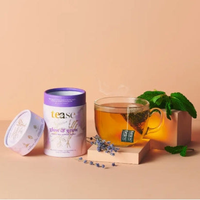 Tea packaging with a glass of tea and mint leaves on a beige background