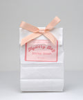 White bag with a pink ribbon and 'Mystery Bag Sticker Stash' label on a gray background