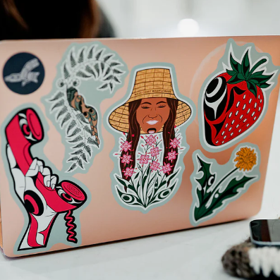 Laptop with various stickers on a white surface