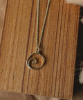Necklace with a spiral pendant on a wooden surface