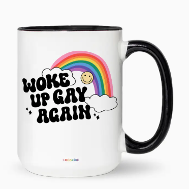 Mug with rainbow, smiley face, and text 'Woke Up Gay Again' on a white background