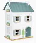 Toy house with a white exterior, green roof, and door on a white background