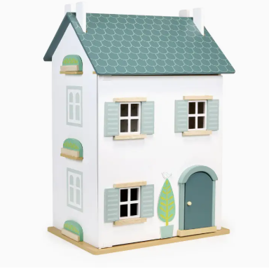 Toy house with a white exterior, green roof, and door on a white background